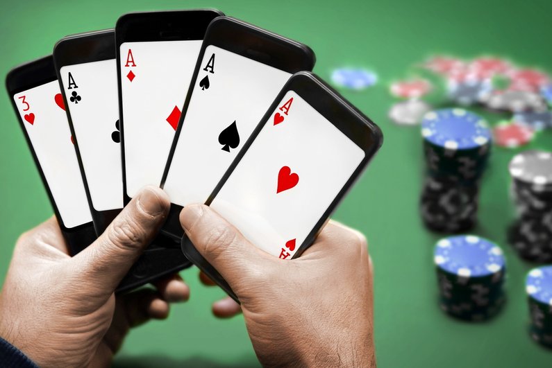 Person playing poker, holding five smartphones like they are playing cards